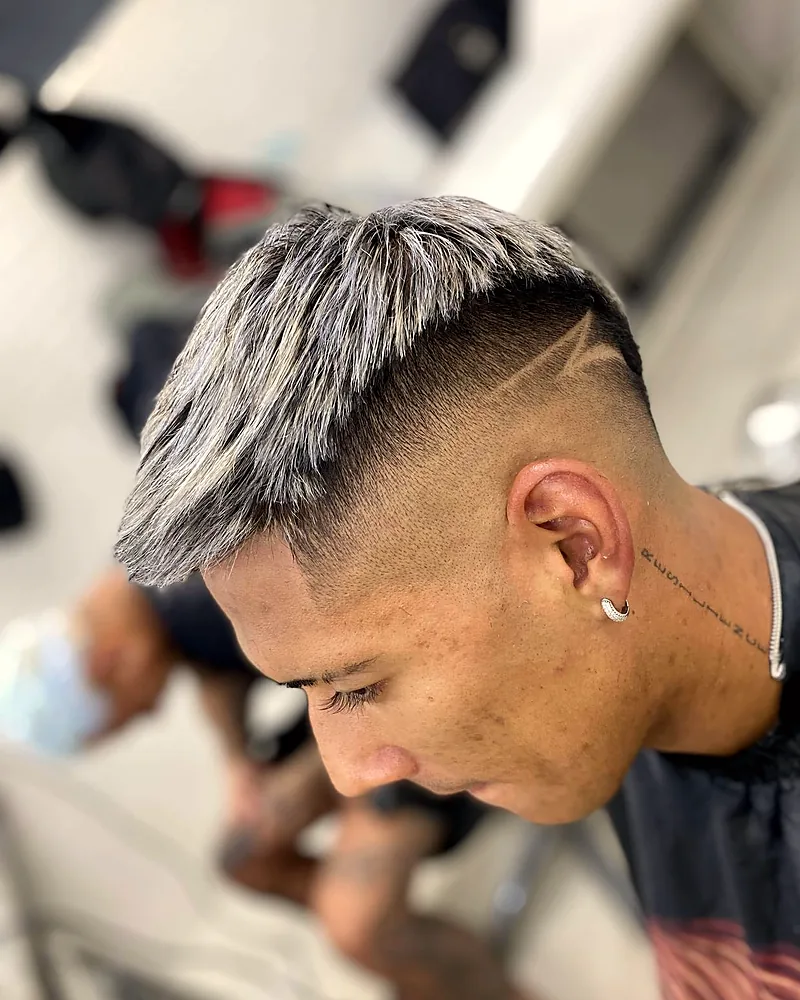 Matías Zaracho com o cabelo platinado, degradê e risco na lateral, feitos pelo Mateus