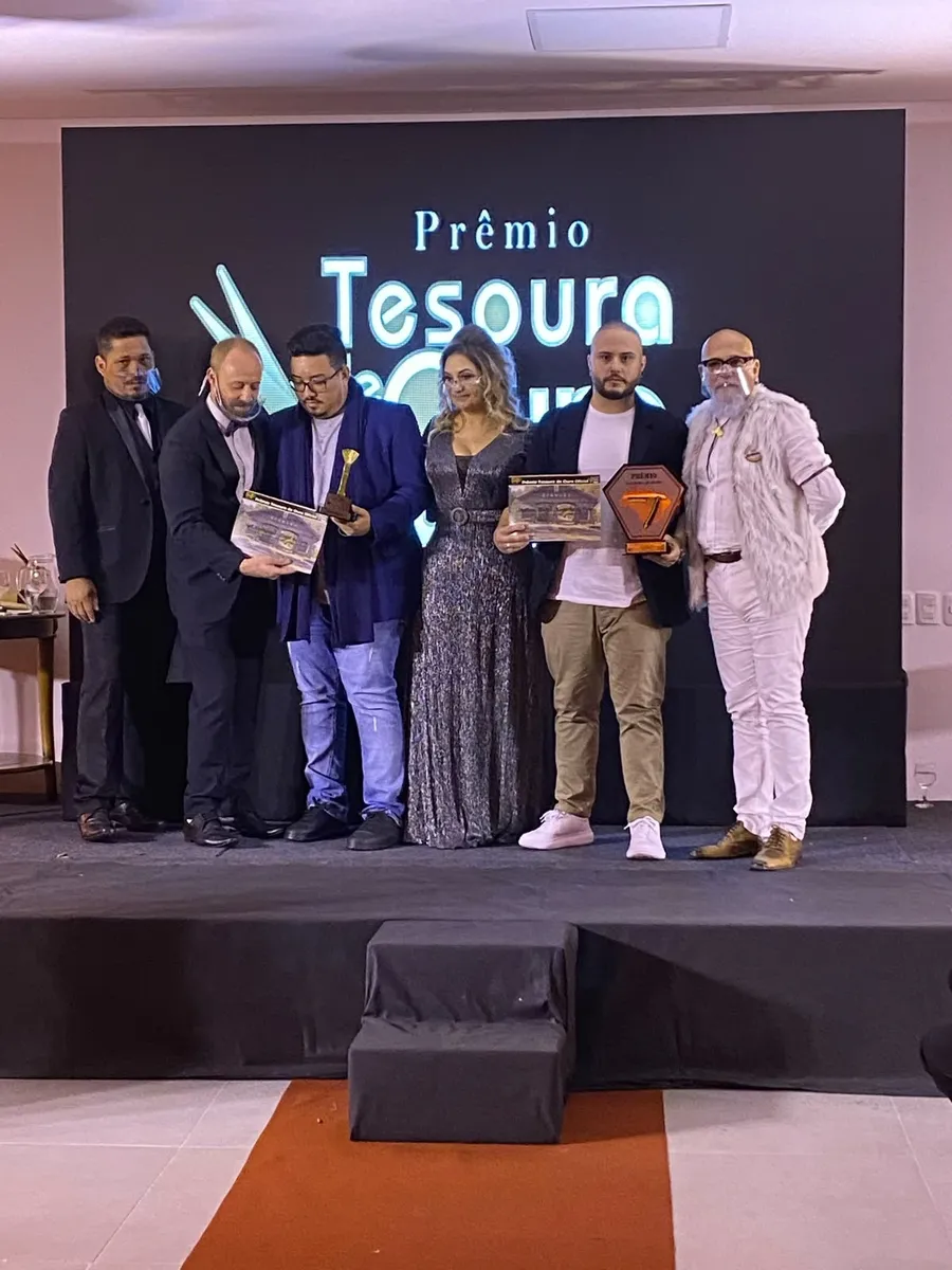 Mateus Rech no palco do Prêmio Tesoura de Ouro recebendo o troféu Navalha de Ouro