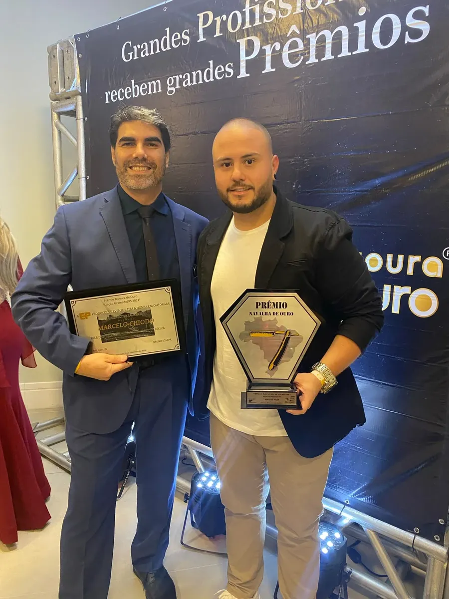 Mateus Rech segurando o troféu Prêmio Navalha de Ouro 2021