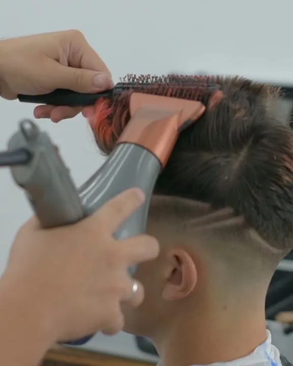 Secador e escova direcionando o penteado