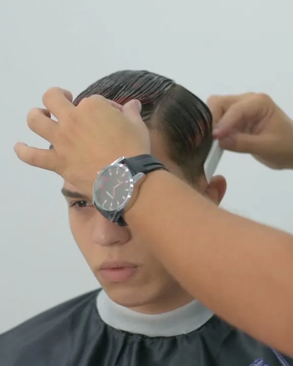 Mateus dividindo o cabelo com o pente antes do fade